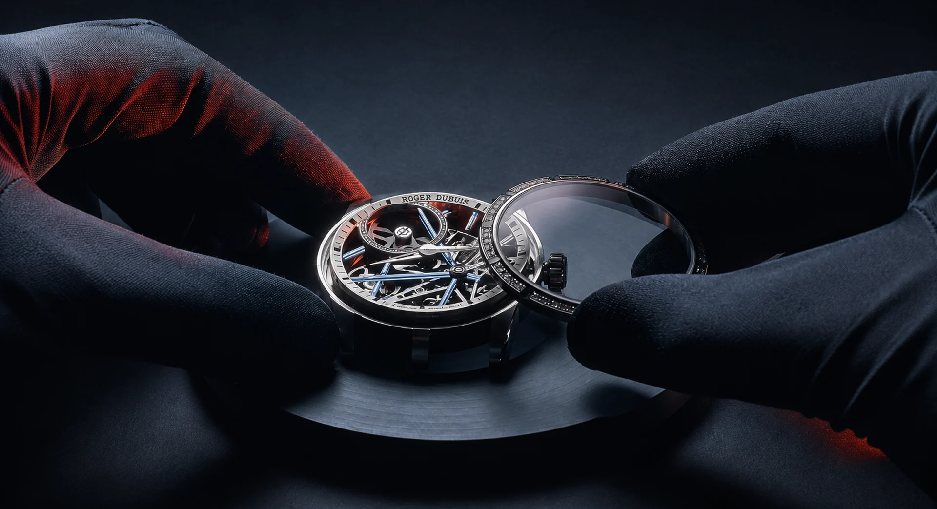 A watchmaker's gloved hands lifting the sapphire crystal from a skeleton tourbillon